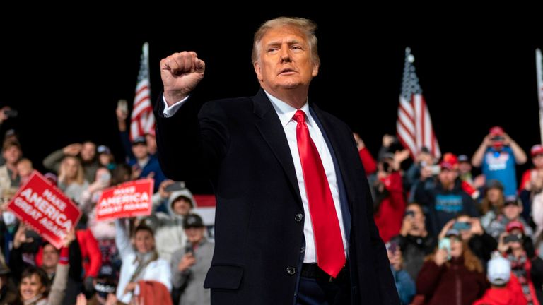 US President Donald Trump holds up his fist as he leaves the stage at the end of a rally to support Republican Senate candidates at Valdosta Regional Airport in Valdosta, Georgia on December 5, 2020. 