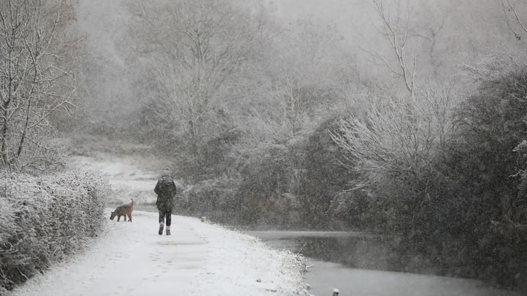 A dog walker braves the snow at Woolsthorpe Locke in Leicestershire.