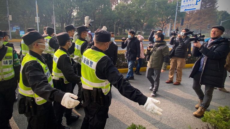 Police attempt to stop journalists from recording footage outside the Shanghai Pudong New District People&#39;s Court, where Chinese citizen journalist Zhang Zhan - who reported on Wuhan&#39;s Covid-19 outbreak and placed under detention since May - is set for trial in Shanghai on December 28, 2020. (Photo by Leo RAMIREZ / AFP) (Photo by LEO RAMIREZ/AFP via Getty Images)
