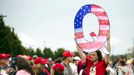 FILE - In this Aug. 2, 2018, file photo, a protesters holds a Q sign waits in line with others to enter a campaign rally with President Donald Trump in Wilkes-Barre, Pa. Facebook and Twitter promised to stop encouraging the growth of the baseless conspiracy theory QAnon, which fashions President Donald Trump as a secret warrior against a supposed child-trafficking ring run by celebrities and government officials. But the social media companies haven’t succeeded at even that limited goal, a revie