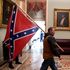 Man pictured carrying Confederate flag into Capitol charged after his son brags to co-worker