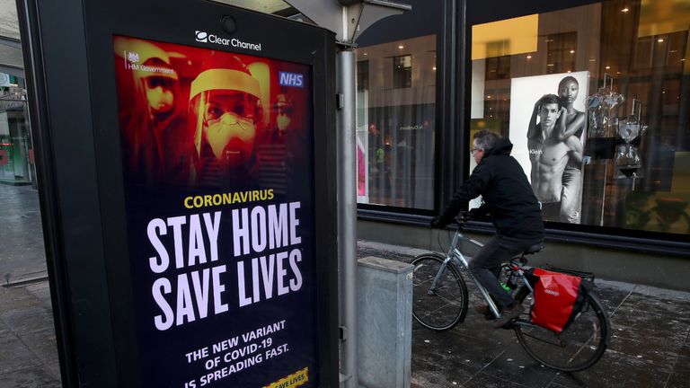 Members of the public cycles passed a coronavirus related advert on a bus stop in Glasgow , where strict lockdown measures for mainland Scotland are in force.