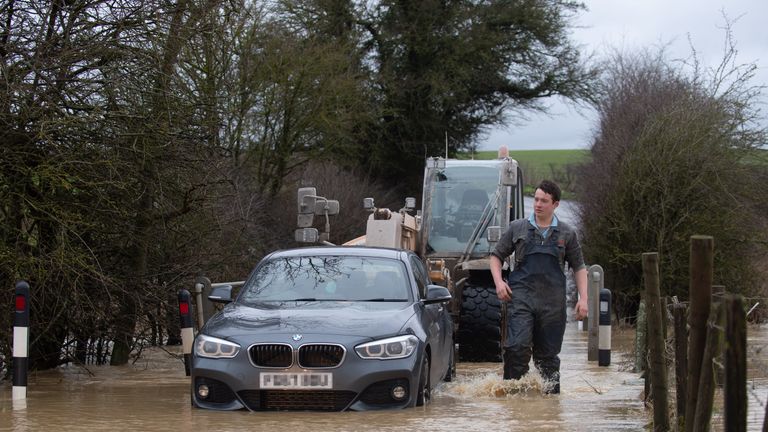 NUMBER PLATE PIXELLATED BY PA PICTURE DESK A local farmer helps rescue a stranded motorist from a flood on Hamilton Road in Leicester. Picture date: Tuesday January 19, 2021.