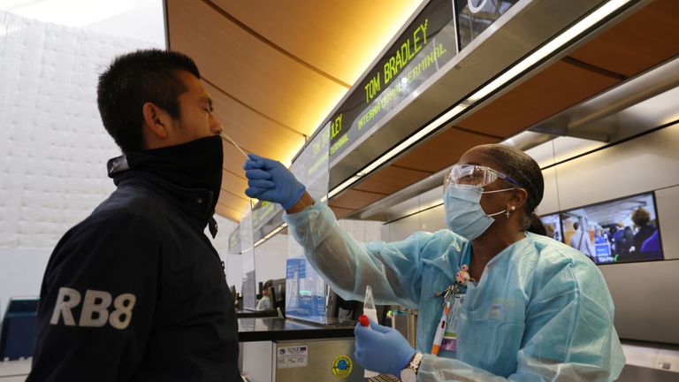 Scott Fujii, 34, is given a 24-hour rapid coronavirus test by nurse Caren Williams at Tom Bradley international terminal at LAX airport so he can travel to Hawaii to see family, as the global outbreak of the coronavirus disease (COVID-19) continues, in Los Angeles, California, U.S., November 23, 2020. REUTERS/Lucy Nicholson