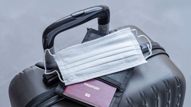 Passeport et masque médical sur valise de voyage.  Concevoir l'interdiction de voyager pendant l'épidémie.