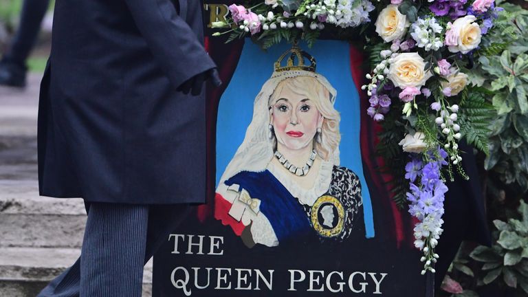 A painted pub sign is carried into the venue for &#39;The Queen Peggy&#39;