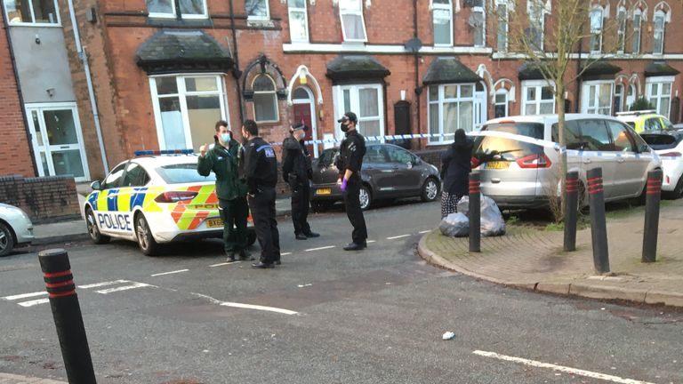Police officers and paramedics are pictured at the scene in Birmingham