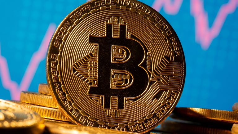 Une représentation de la monnaie virtuelle Bitcoin est vue devant un graphique boursier dans cette illustration prise le 19 novembre 2020