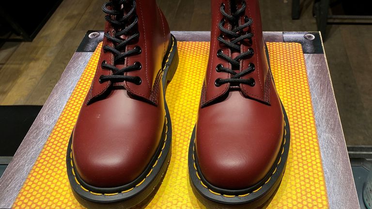 A pair of Dr. Martens boots, a bottle of hand sanitiser, and social distancing signage seen through the window of a Dr Martens shop amid the outbreak of the coronavirus disease (COVID-19) in London, Britain, September 17, 2020.