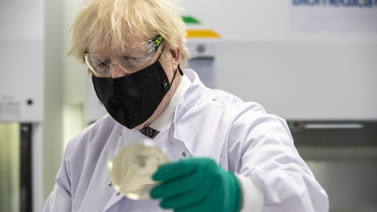 Prime Minister Boris Johnson looks at a petri dish in the quality control laboratory, where batches of vaccine are tested, during a tour of the manufacturing facility for the Oxford/Astrazeneca vaccine at Oxford Biomedica in Oxfordshire