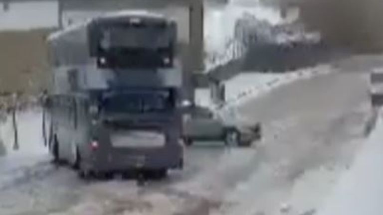 Bus narrowly misses vehicle as it slides along icy road