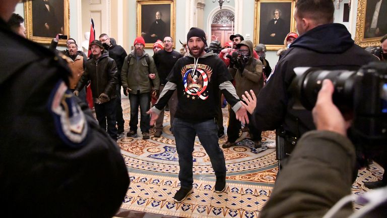 A supporter of President Donald Trump confronts police as Trump supporters demonstrate on the second floor of the U.S. Capitol near the entrance to the Senate after breaching security defenses, in Washington, U.S., January 6, 2021. REUTERS/Mike Theiler