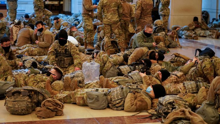 Several National Guard members are pictured lying on the floor of the U.S. Capitol 