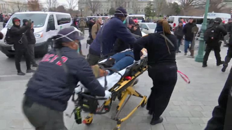 The shot woman is taken away by paramedics