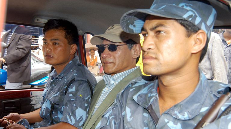 French national Charles Sobhraj (C) takes a taxi back to jail while accompanied by guards in the Nepalese capital Kathmandu July 5, 2004. Nepali authorities on Monday charged the notorious criminal Sobhraj, known as "the Serpent" and the "Bikini Killer", with the 1975 murder of an American backpacker in Kathmandu. REUTERS/Gopal Chitrakar GC/TW
