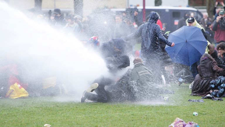 Dutch anti-riot police spray water cannon against protestors to disperse an illegal anti-coronavirus measures demonstration in Amsterdam, Netherlands. Pic: AP images