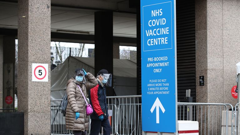 People in face coverings, leave after receiving their COVID-19 vaccinations at the Olympic Office Centre, in Wembley, north London