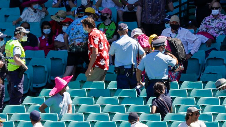 Police escort spectators from the stands during play on day four of the third test