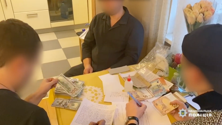 Police officers recorded the serial number of seized bank notes. Pic: National Police of Ukraine