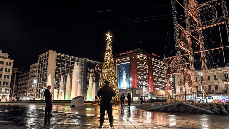 Police officers patrol at the central square in Athens, Greece, during a curfew imposed after 10pm