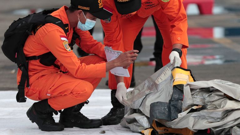 Rescuers inspects debris found in the waters around the location where a Sriwijaya Air passenger jet has lost contact with air traffic controllers shortly after take off, at the search and rescue command center at Tanjung Priok Port in Jakarta, Indonesia, Sunday, Jan. 10, 2021. The Boeing 737-500 took off from Jakarta for Pontianak, the capital of West Kalimantan province on Indonesia...s Borneo island, and lost contact with the control tower a few moments later. (AP Photo/Dita Alangkara)