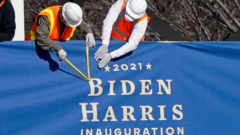 Workers put up bunting for the inauguration in front of the White House