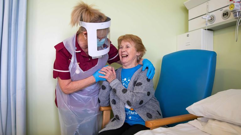 Margaret Keenan, 90, who was the first patient in the United Kingdom to receive the Pfizer-BioNtech Covid-19 vaccine, reacts as she talks with Healthcare assistant Lorraine Hill, while preparing to leave University Hospital Coventry, in Coventry on December 9, 2020, a day after receiving the vaccine. - Britain on December 8 hailed a turning point in the fight against the coronavirus pandemic, as it begins the biggest vaccination programme in the country's history