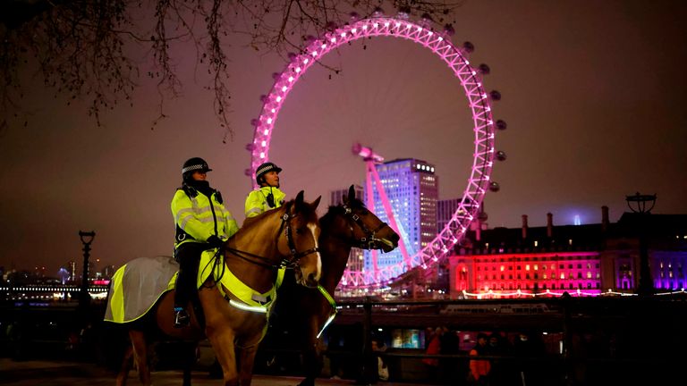 Officers patrol The Victoria Embankment opposite the London Eye in a near-deserted London 