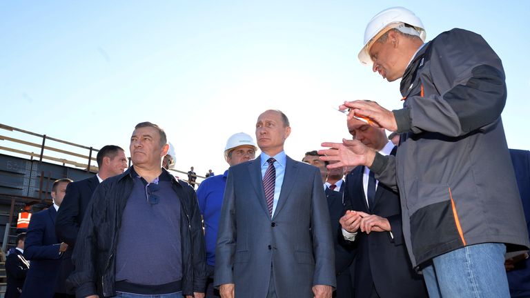 Russian President Vladimir Putin (C) and businessman Arkady Rotenberg (L) visits the site of the construction of a bridge across the Kerch Strait in Kerch, Crimea,