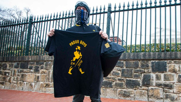 A member of the Virginia chapter of the Proud Boys sells T-shirts  Pic: AP Photo/John C. Clark