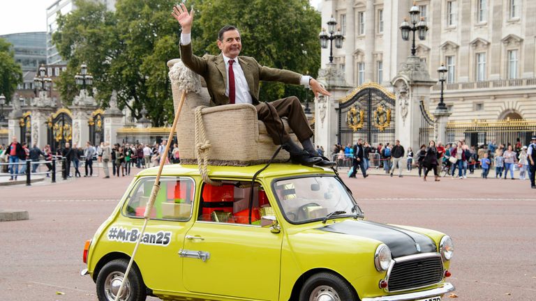 British actor Rowan Atkinson, dressed as Mr Bean, sits on top of a Mini Cooper outside Buckingham Palace, London, to promote the 25th anniversary of Mr Bean, London, Friday, Sept. 4, 2015. (Photo by Jonathan Short/Invision/AP)