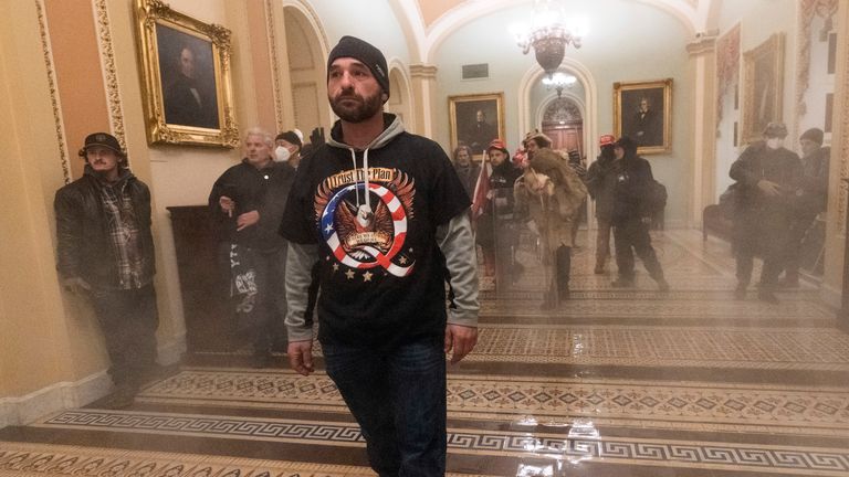 Smoke fills the walkway outside the Senate Chamber as supporters of President Donald Trump are confronted by U.S. Capitol Police officers inside the Capitol, Wednesday, Jan. 6, 2021 in Washington. (AP Photo/Manuel Balce Ceneta)