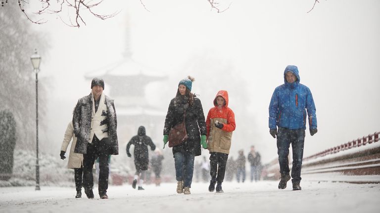 People walking in the snow in Battersea Park, London