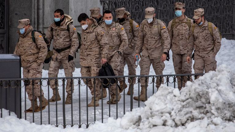 Members of the military walks through snow in downtown Madrid, Spain, Sunday, Jan. 10, 2021. A large part of central Spain including the capital of Madrid are slowly clearing snow after the country&#39;s worst snowstorm in recent memory. (AP Photo/Manu Fernandez)