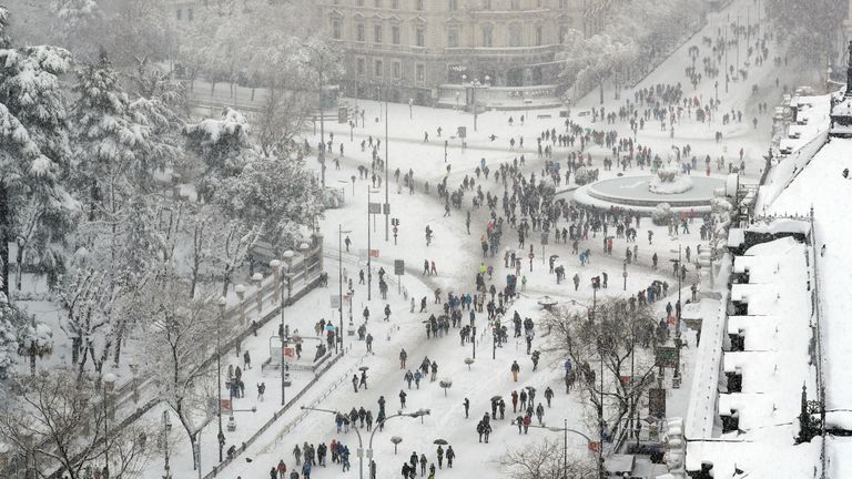 People are seen from the rooftop of the Circulo de Bellas Artes cultural center, as they stand and walk near the Cibeles Fountain during a heavy snowfall in Madrid, Spain January 9, 2021. REUTERS/Susana Vera
