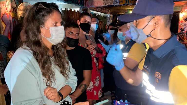 In this Tuesday, Jan. 26, 2021, Thai immigration officers talk to people at a bar on Koh Phangan island, Surat Thani province, southern Thailand. Police raided a party at a bar on a popular resort island in southern Thailand and arrested 89 foreigners for violating coronavirus regulations, officials said Wednesday. Pic: AP