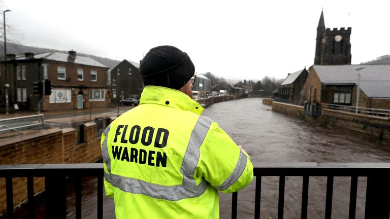 A flood warden inspects River Calder water levels in Mytholmroyd, West Yorkshire