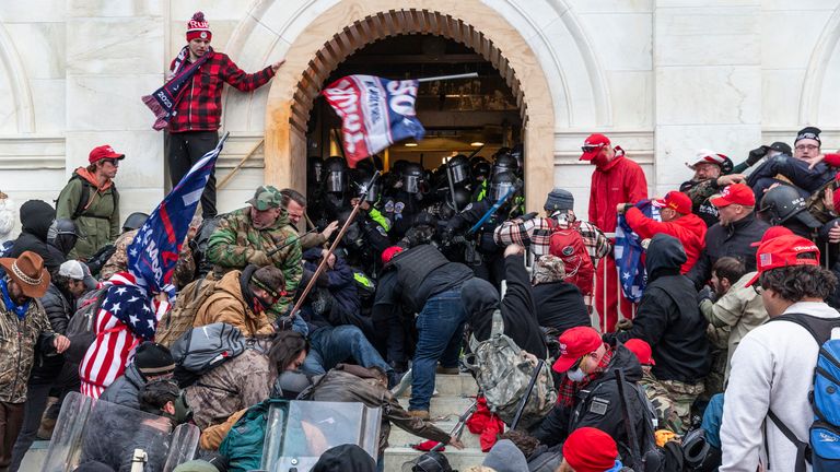 WASHINGTON DC, DISTRICT OF COLUMBIA, UNITED STATES - 2021/01/06: Rioters clash with police trying to enter Capitol building through the front doors. Rioters broke windows and breached the Capitol building in an attempt to overthrow the results of the 2020 election. Police used batons and tear gas grenades to eventually disperse the crowd. Rioters used metal bars and tear gas as well against the police. (Photo by Lev Radin/Pacific Press/LightRocket via Getty Images)