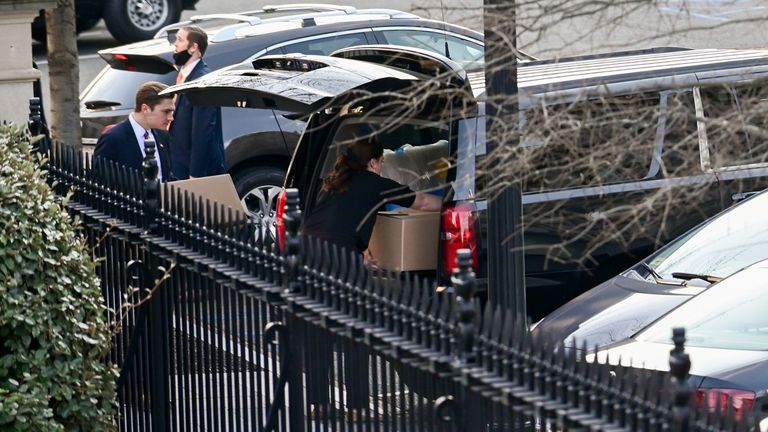 Boxes and other items from the West Wing of the White House are loaded into a car 