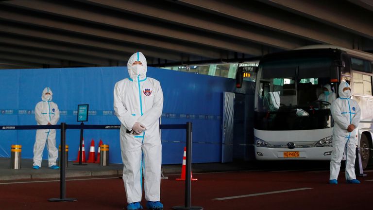 Lokale Beamte am Flughafen Wuhan warten auf die Ankunft von WHO-Beamten in Schutzanzügen 