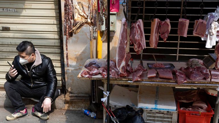 AP: In this photo taken Friday, April 3, 2020, a vendor waits for customers at a stall near a still partially closed off market due to the coronavirus outbreak in Wuhan in central China's Hubei province. (AP Photo/Ng Han Guan)