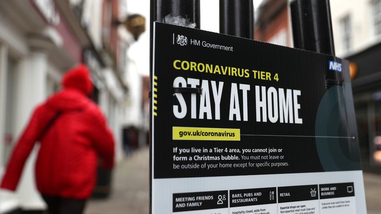 People make their way past a Government coronavirus Tier 4 sign on the High street in Winchester, Hampshire. Millions more people have moved to harsher coronavirus restrictions today as the new tier changes came into force in England.