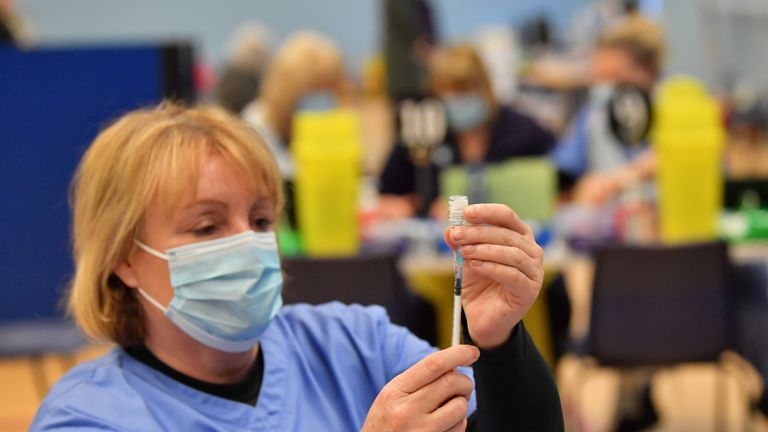 Health care workers give out injections of the Pfizer vaccine at a coronavirus vaccination centre set up at Cwmbran Stadium, south Wales. Picture date: Tuesday January 26, 2021.