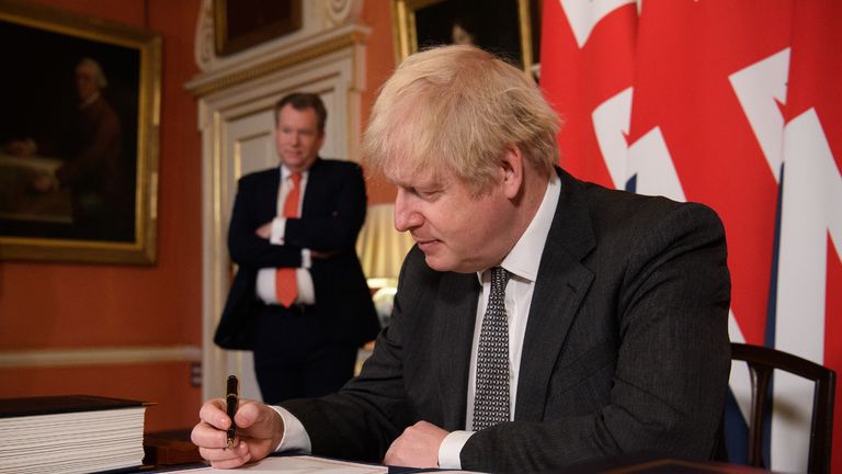 UK chief trade negotiator, David Frost looks on as Prime Minister Boris Johnson signs the EU-UK Trade and Cooperation Agreement at 10 Downing Street, Westminster.