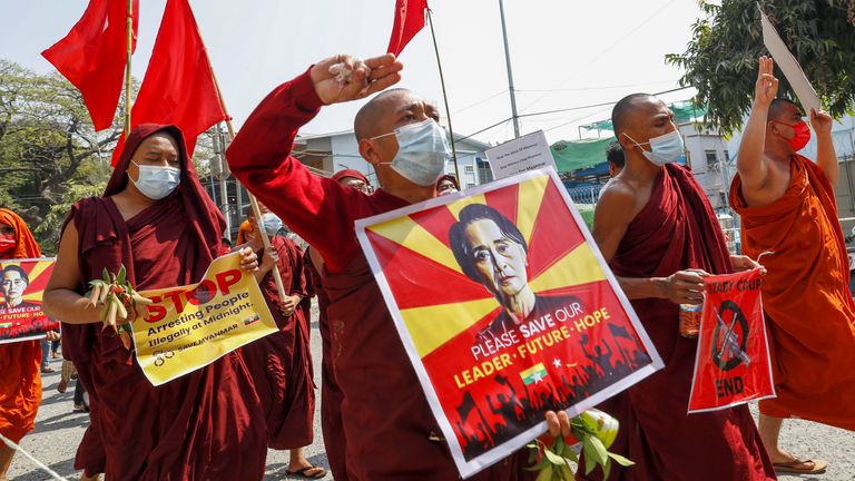 Buddhist monks and nuns display pictures of detained Myanmar leader Aung San Suu Kyi during a protest against the military coup in Mandalay, Myanmar on Tuesday, Feb. 16, 2021. Security forces in Myanmar pointed guns toward anti-coup protesters and attacked them with sticks Monday, seeking to quell the large-scale demonstrations calling for the military junta that seized power this month to reinstate the elected government. (AP Photo)