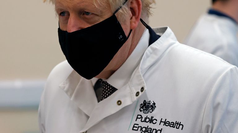 Britain&#39;s Prime Minister Boris Johnson wearing a mask because of the novel coronavirus pandemic talks to staff during a visit to the Public Health England site at Porton Down science park near Salisbury, southern England, on November 27, 2020. (Photo by Adrian DENNIS / POOL / AFP)