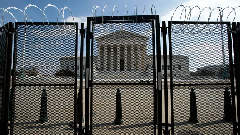 La Cour suprême américaine est vue à travers une clôture avec du fil de fer barbelé, mercredi 10 février 2021 à Washington, alors que le deuxième procès de destitution de l'ancien président Donald Trump se poursuit au Capitole.  (Photo AP / Jose Luis Magana)