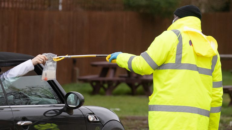 Un test de coronavirus est remis par la fenêtre d'une voiture dans le parking du Hampshire