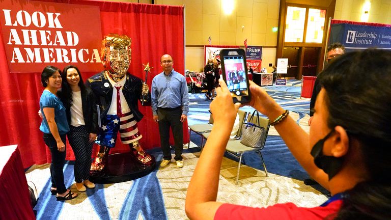 A gold statue of the former president wearing flip flops and carrying a wand has proven a big draw for delegates. Pic: AP