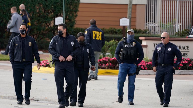 Law enforcement officers walk near the entrance to an apartment complex where the shooting occurred. Pic: AP Photo/Marta Lavandier